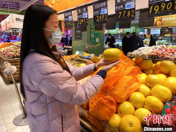 陈家良、杨洪益一家挑选、购买年夜饭食材。　陈雅欣 摄