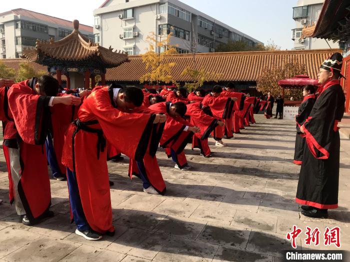 11月12日，济台两地80余名中学生在山东济南府学文庙前行中华传统成人礼。　张钰 摄