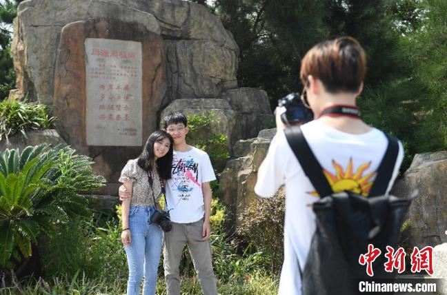 一对台湾情侣在洞头半屏山以同源同根碑为背景合影。　王刚 摄
