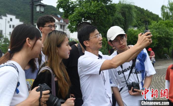 台湾青年在龙门古镇观摩学习无人机拍摄。　王刚 摄