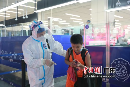 港珠澳大桥边检站民警协助无陪同人的学童通关。 作者 王相国