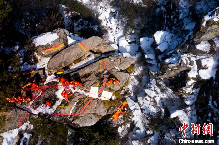 图为消防指战员在积雪覆盖的悬崖边开展绳索救援演练。　傅建斌 摄