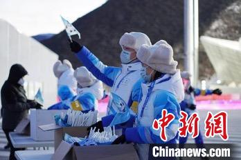 图为志愿者向观众发放冰墩墩旗帜。 北京冬奥组委供图
