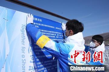 图为志愿者张贴观赛须知。 北京冬奥组委供图