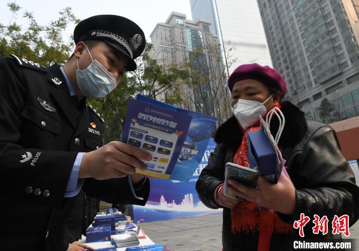 民警向市民讲解如何防电信诈骗。　周毅 摄