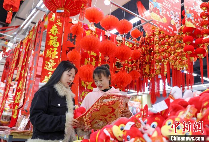 2023年1月10日，市民在贵州省黔东南苗族侗族自治州施秉县年货集市选购新春饰品。　磨桂宾 摄